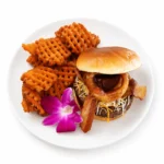 Whiskey BBQ Burger topped with bacon, onion rings, cheese, and whiskey BBQ sauce served with crispy sweet potato waffle fries