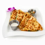 Breakfast Quesadilla at Eggsquisite Cafe with scrambled eggs, tomatoes, spinach, jalapeños, Monterey Jack and cheddar cheese, and pico de gallo.