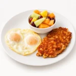 Corned Beef Hash breakfast at Eggsquisite Cafe, served with two eggs and a choice of two breakfast sides like berries or fresh fruit.