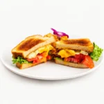 BLT and Egg sandwich at Eggsquisite Cafe with bacon, lettuce, tomatoes, fried egg, and mayo on toasted white bread.