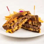Patty Melt at Eggsquisite Cafe with Angus beef on grilled rye bread, melted American cheese, and sautéed onions.