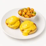 Eggs Benedict at Eggsquisite Cafe with two poached eggs, Canadian bacon, English muffin, and creamy hollandaise sauce.