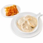 Biscuits and Sausage Gravy at Eggsquisite Cafe with biscuits covered in savory sausage gravy and served with eggs or hash browns.