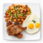 Pork Chops and Eggs at Eggsquisite Cafe with two center-cut pork chops, eggs, and two breakfast sides.