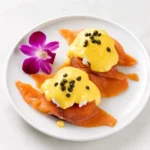 Smoked Salmon Benedict at Eggsquisite Cafe with poached eggs, smoked salmon, tomatoes, cream cheese, English muffin, and hollandaise sauce.