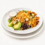 Eggsquisite Chicken Salad at Eggsquisite Cafe with mixed greens, tomatoes, avocado, bacon, Monterey Jack and cheddar cheese, and grilled or fried chicken.