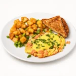 Smoked Salmon Scrambler at Eggsquisite Cafe with scrambled eggs, salmon lox, herbed cream cheese, hollandaise, chives, and potatoes O'Brien.