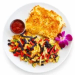 Migas at Eggsquisite Cafe with scrambled eggs, jalapeños, tomatoes, onions, Monterey Jack and cheddar cheese, tortilla strips, hash browns, and salsa.