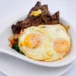 Steak Skillet at Eggsquisite Cafe with roasted red peppers, onions, feta cheese, hash browns, and two eggs.