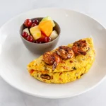Blackened Shrimp Omelette at Eggsquisite Cafe with seasoned shrimp, mushrooms, tomatoes, onions, and Monterey Jack and cheddar cheese.
