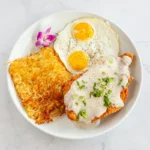 Chicken Fried Steak breakfast at Eggsquisite Cafe, served with two eggs and a choice of two breakfast sides.